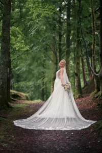Brud i skogen med en lang hvit kjole